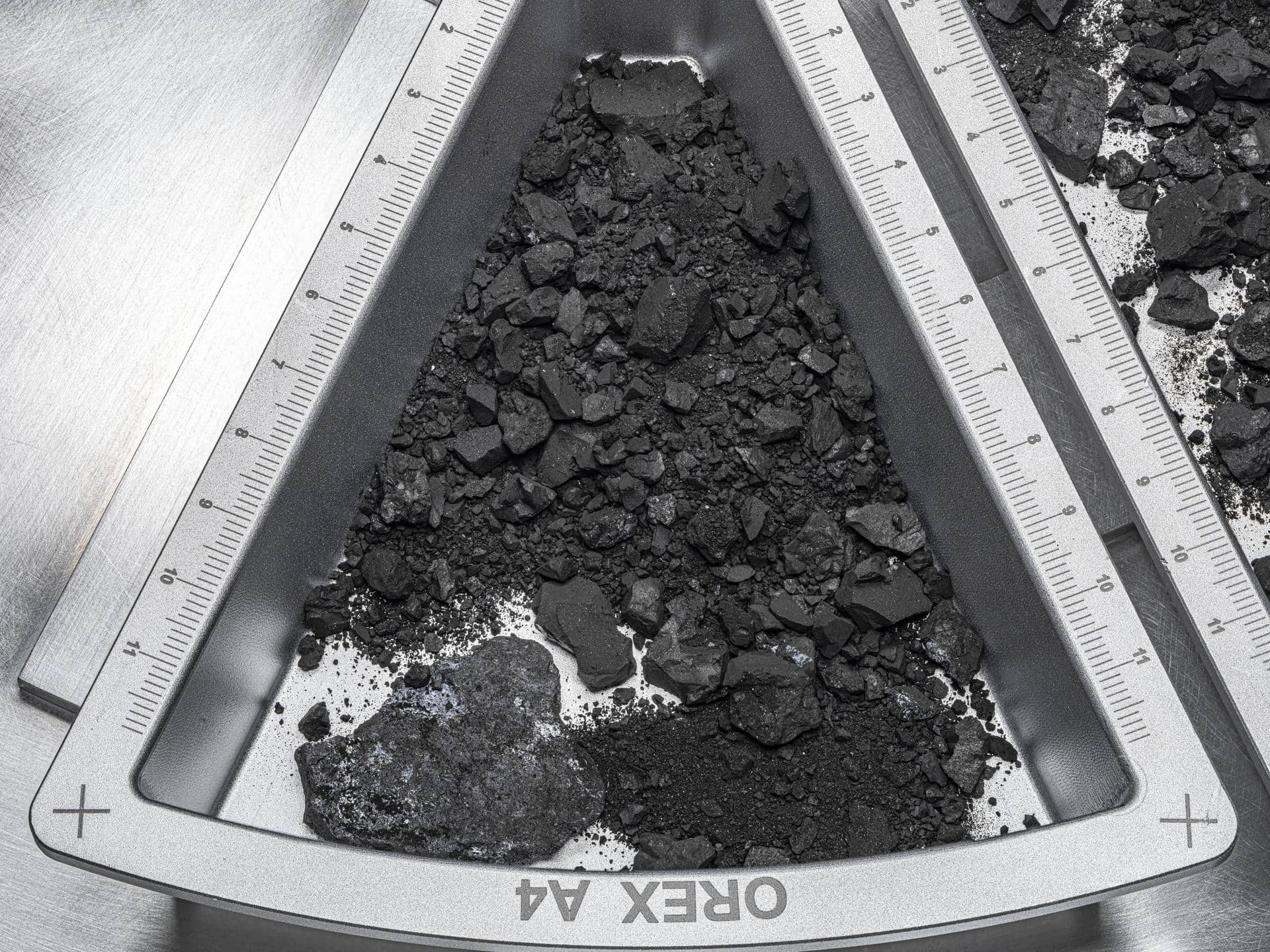 Campioni dell'asteroide Bennu visibili nel contenitore TAGSAM aperto al Johnson Space Center NASA