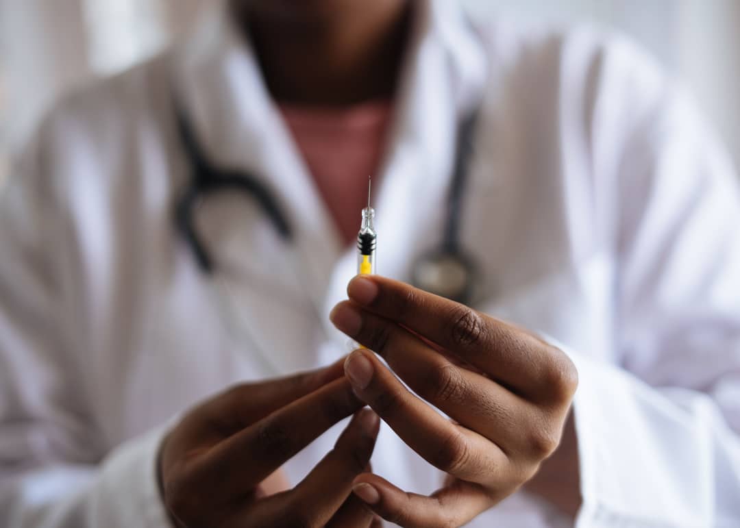 Operatore sanitario che prepara una siringa per una vaccinazione