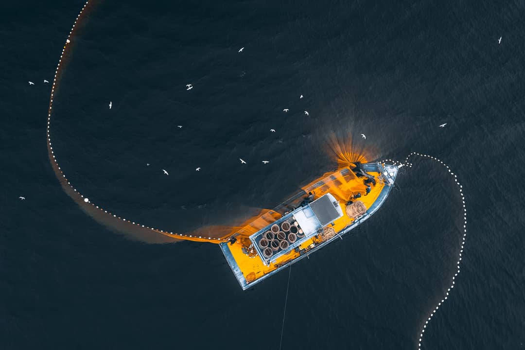 Peschereccio con reti da pesca ripreso dall'alto in mare