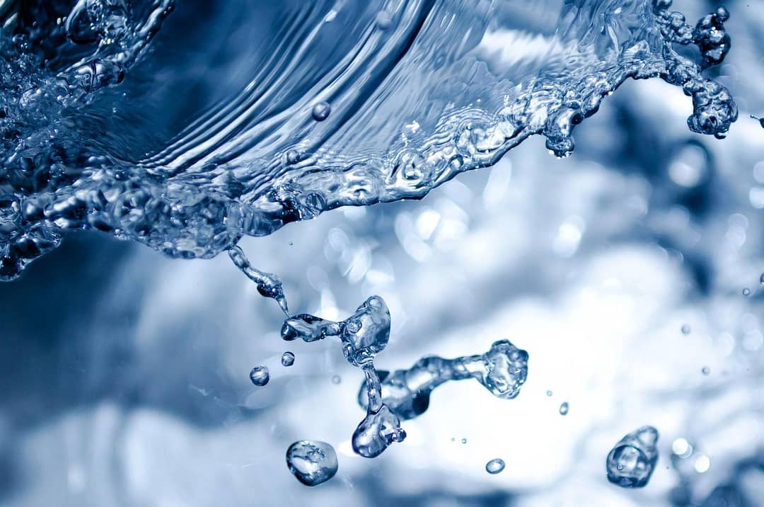 Primo piano di un liquido viscoso in caduta che forma un filo continuo