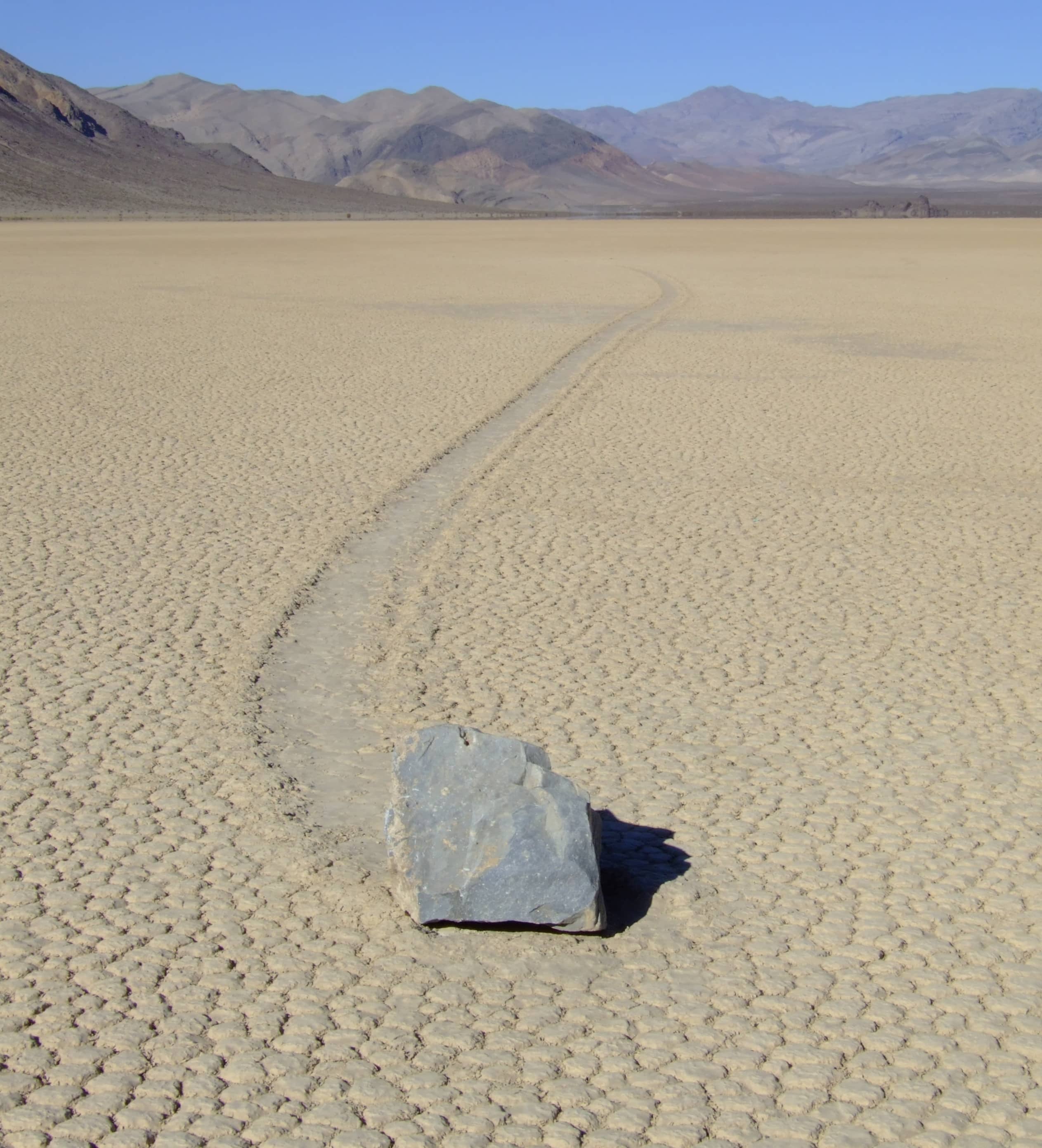 Vista panoramica di Racetrack Playa nel Death Valley National Park, con il fondo screpolato e una pietra in lontananza