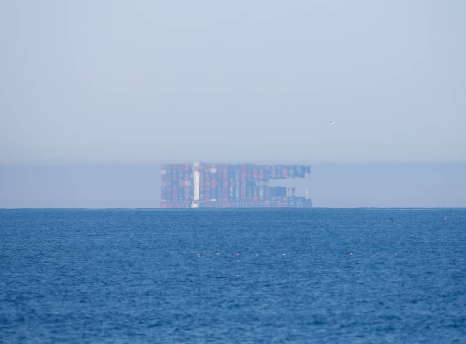 Una nave cargo deformata e sollevata dall'orizzonte da un miraggio Fata Morgana